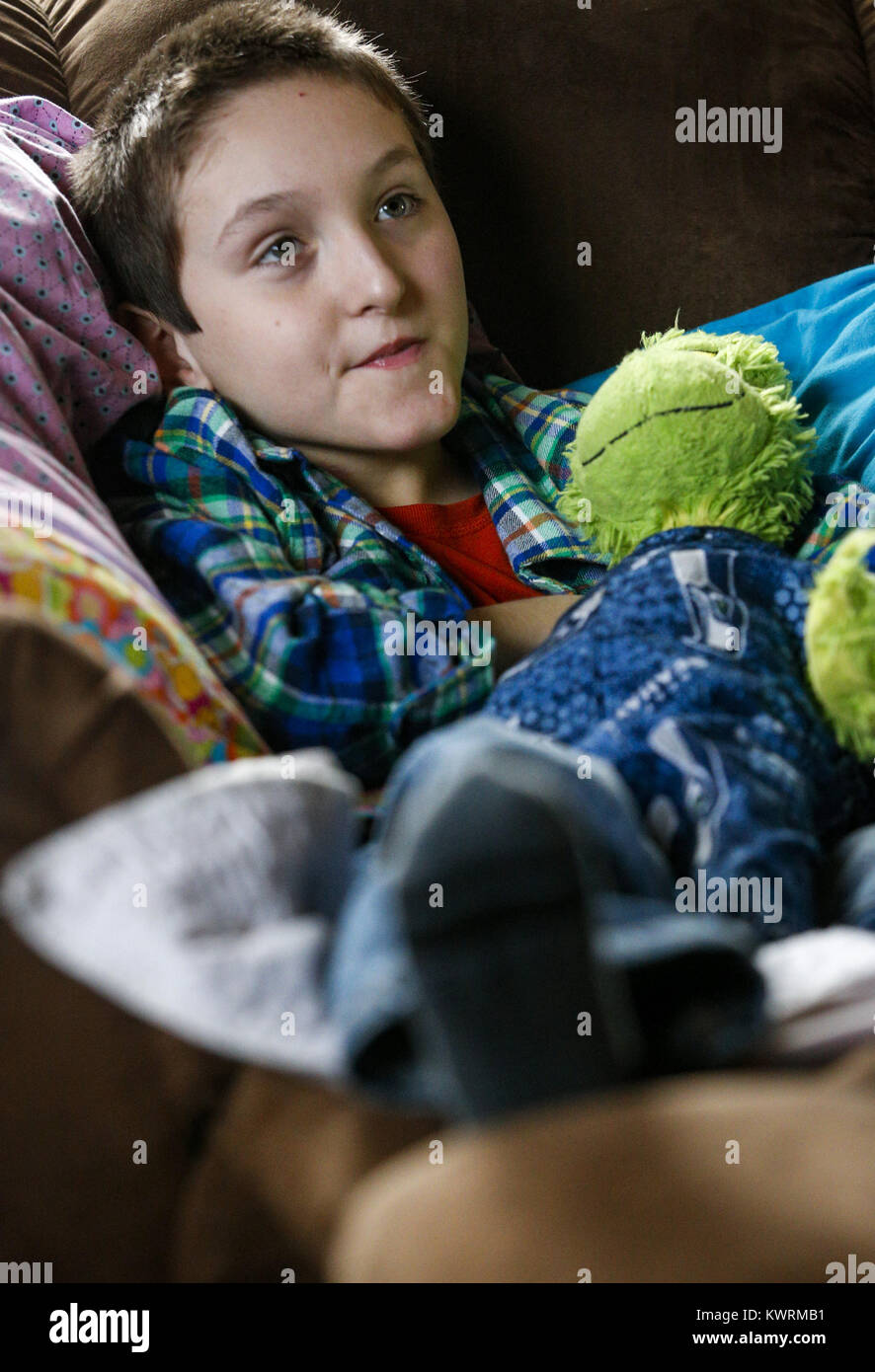 Davenport, Iowa, USA. 12. Januar 2017. Ryan McDermott, 10, sitzt mit seinem Grinch-Puppe in Seattle Seahawks Schlafanzug zu Hause in Davenport McDermott auf Donnerstag, 12. Januar 2017 gekleidet. McDermott war als Kleinkind mit Dravet-Syndrom, einer schweren Form von Epilepsie diagnostiziert und hat derzeit zwischen 10 und 20 Anfälle pro Tag. Eine Cannabis-Öl-Studie durch die Universität von Iowa funktionierte nicht für McDermott, aber er wird in Kürze eine Studie durch die Mayo-Klinik namens Fenfluramin Bewertung bei seltenen Epilepsie beginnen. Bildnachweis: Andy Abeyta/Quad-Stadt-Zeiten / ZUMA Draht/Alamy Live News Stockfoto