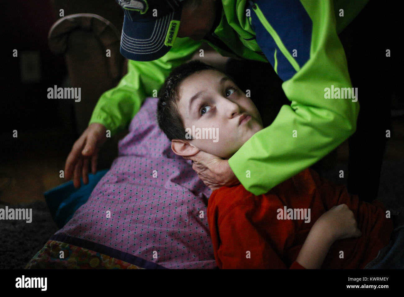 Davenport, Iowa, USA. 12. Januar 2017. Tina McDermott Orte Kissen unter ihrem Sohn den Kopf um ihn nach einer Pfändung zu Hause in Davenport McDermott auf Donnerstag, 12. Januar 2017 neu zu positionieren. Ryan McDermott, 10, wurde als Kleinkind mit Dravet-Syndrom, einer schweren Form von Epilepsie diagnostiziert und hat derzeit zwischen 10 und 20 Anfälle pro Tag. Eine Cannabis-Öl-Studie durch die Universität von Iowa funktionierte nicht für McDermott, aber er wird in Kürze eine Studie durch die Mayo-Klinik namens Fenfluramin Bewertung bei seltenen Epilepsie beginnen. Bildnachweis: Andy Abeyta/Quad-Stadt-Zeiten / ZUMA Draht/Alamy Live News Stockfoto