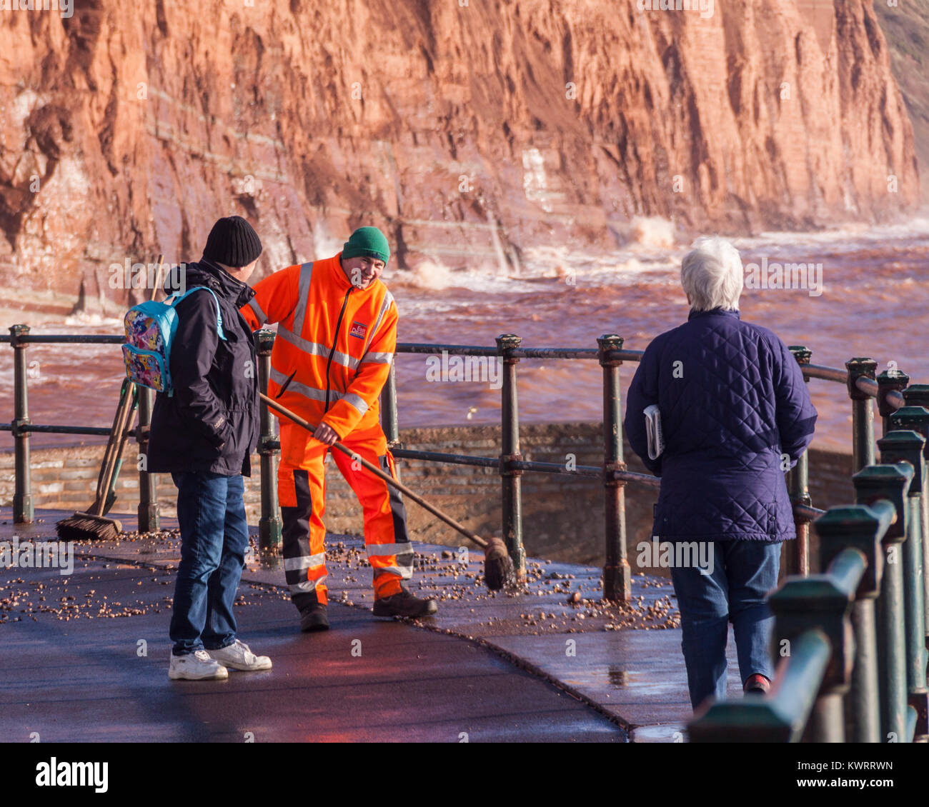 Honiton, Devon. 5 Jan, 2018. UK Wetter: Rat Arbeitnehmer versuchen zu fegen, der Tonnen von Schiefer und Kiesel, Sidmouth Esplanade in den Nachwehen des Sturms Eleanor abdecken. Credit: Foto Central/Alamy leben Nachrichten Stockfoto