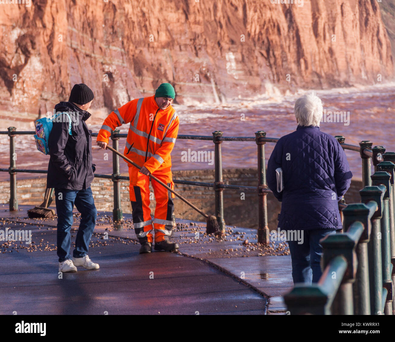 Honiton, Devon. 5 Jan, 2018. UK Wetter: Rat Arbeitnehmer versuchen zu fegen, der Tonnen von Schiefer und Kiesel, Sidmouth Esplanade in den Nachwehen des Sturms Eleanor abdecken. Credit: Foto Central/Alamy leben Nachrichten Stockfoto