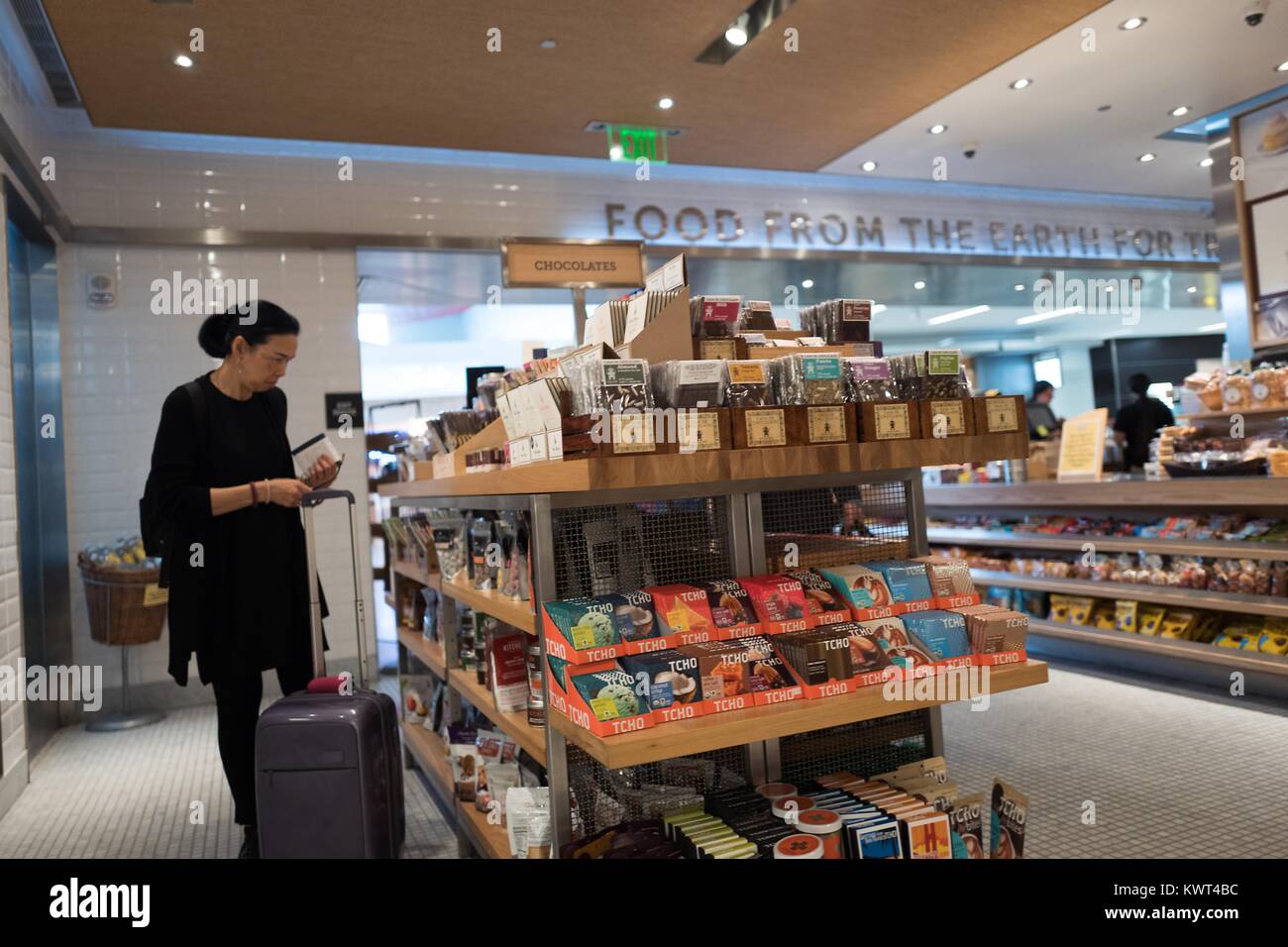 Eine Frau durchsucht handwerkliche Pralinen bei Napa Farmen Markt, ein gourmet Bauernhof-zu-Tabelle Food Store am Flughafen San Francisco International (SFO), San Francisco, Kalifornien, USA, 13. September 2017. Stockfoto