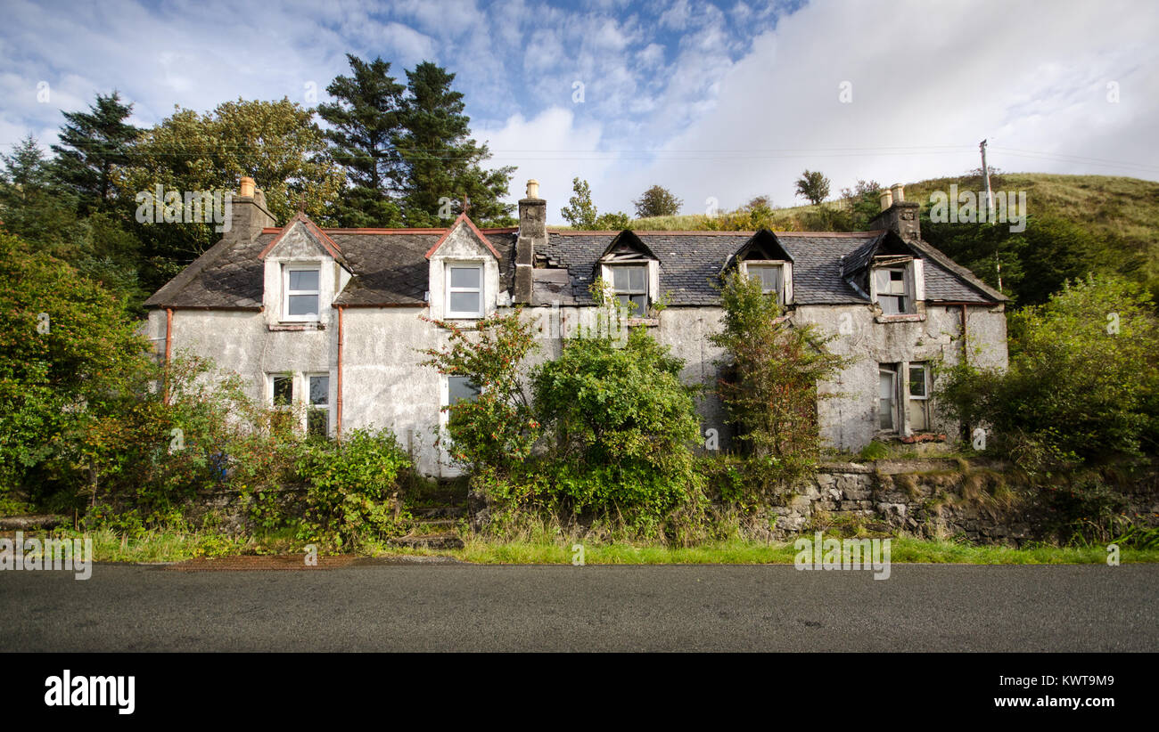 Ein teilweise verfallenen und beschädigte Haus ist mit Sträuchern in dem abgelegenen Dorf von Uig auf der Isle of Skye in den Highlands von Schottland überwuchert. Stockfoto