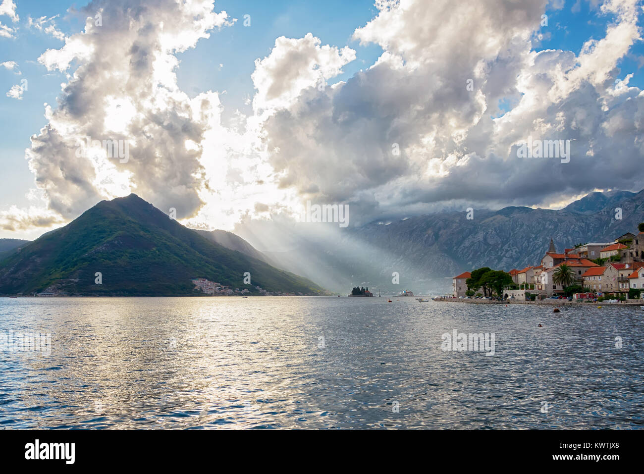 Sonnenstrahlen durch die Wolken in der fjordähnlichen Bucht von Kotor, altes Dorf Perast, Crna Gora, Montenegro, Balkan, Europa Stockfoto