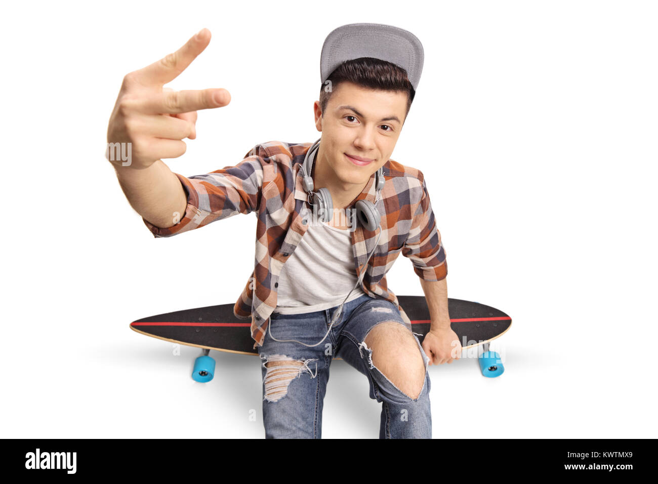 Teenage hipster Sitzen auf einem longboard und einen Frieden Geste auf weißem Hintergrund Stockfoto