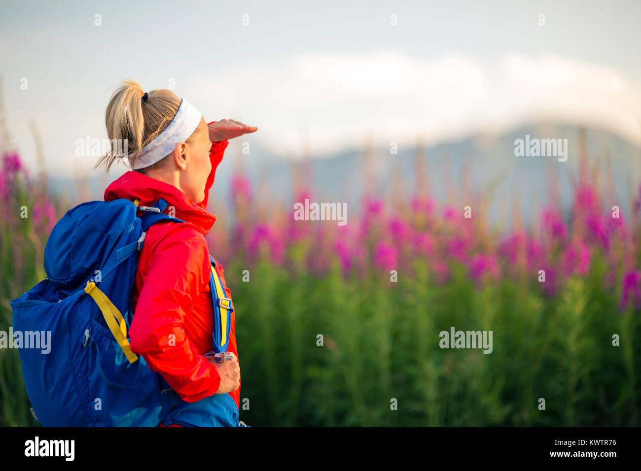 Frau wandern und Wandern in den Bergen mit Rucksack. Blick auf schöne Aussicht. Reisen und Wandern im Sommer Natur, inspirierende Gesundheit und Fitness con Stockfoto