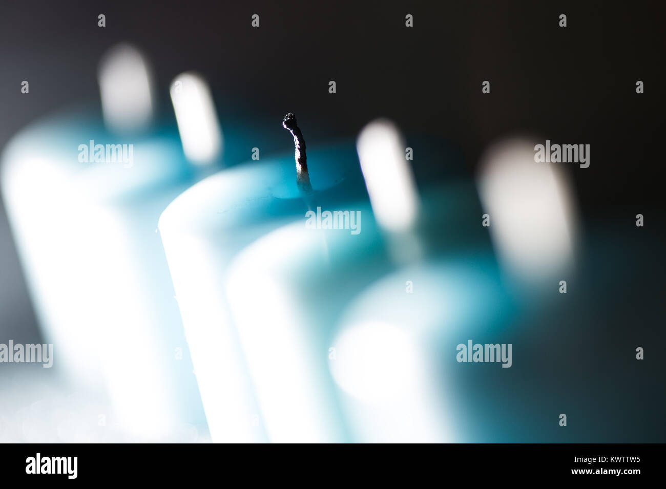 Fünf blauen Kerzen in einer Reihe auf einem schwarzen Hintergrund Stockfoto