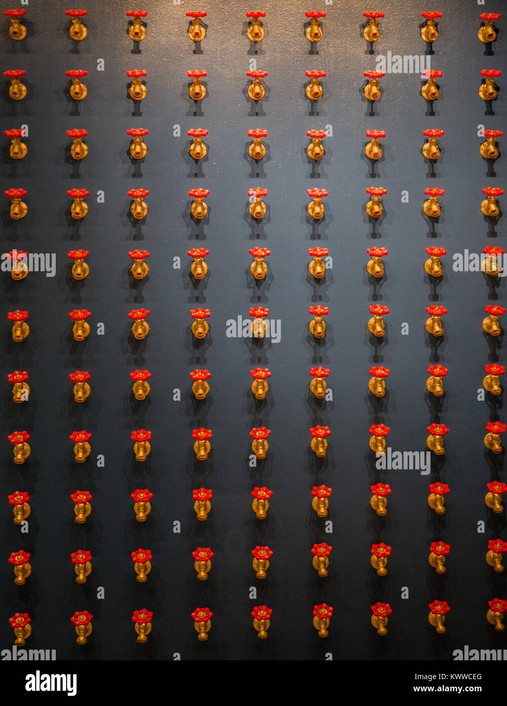 Rote Hähne an einer Wand Stockfoto