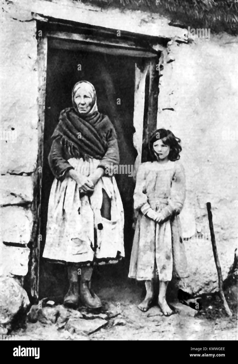 1921 Eine irische Bauernmädchen steht neben ihrer Großmutter außerhalb Ihres Cottage Stockfoto
