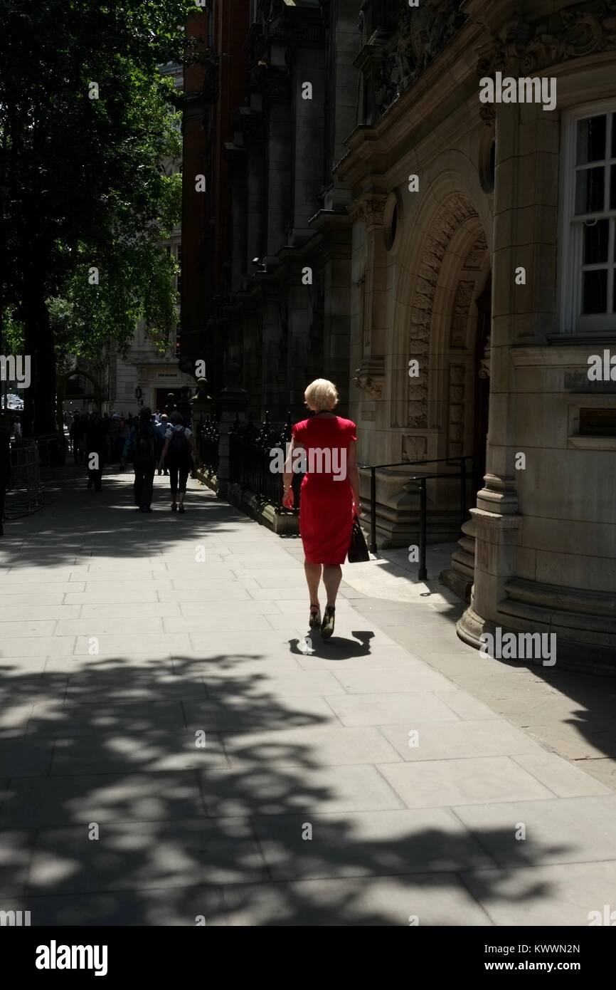 Frau in Rot, Wandern in Westminster, London Stockfoto