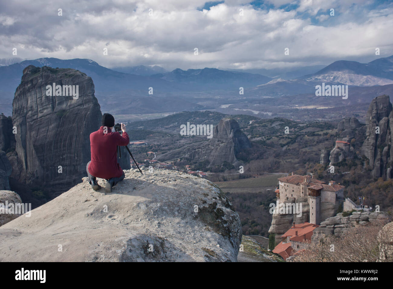 Reisende mann Fotografen mit professionellen Kamera und Stativ, am Rande von einer hohen Klippe, nimmt Bilder von riesigen Felsen und Klöster von Meteora Stockfoto