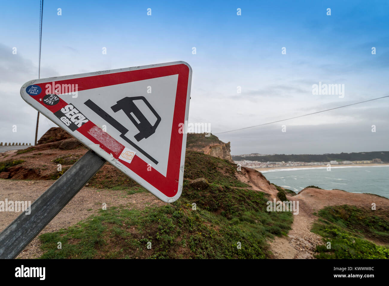Unebenen Straßen mit Warnschild, auf Klippen bei Nazare, Portugal Stockfoto