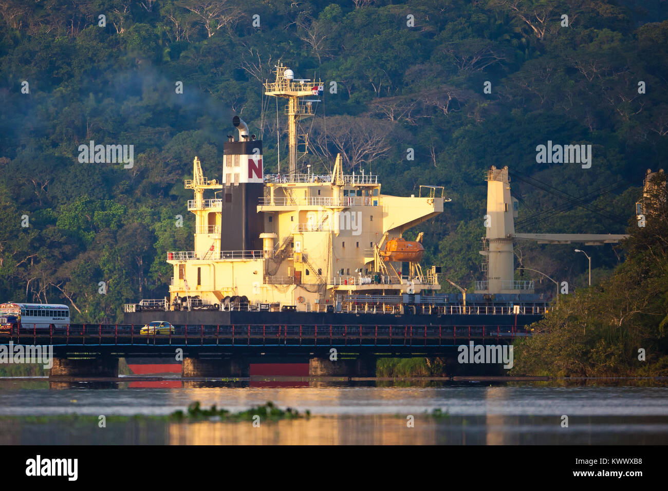 Schiff durch den Panamakanal, Republik Panama. Im Vordergrund steht die Auto- und Eisenbahnbrücke über Rio Chagres bei Gamboa. Stockfoto