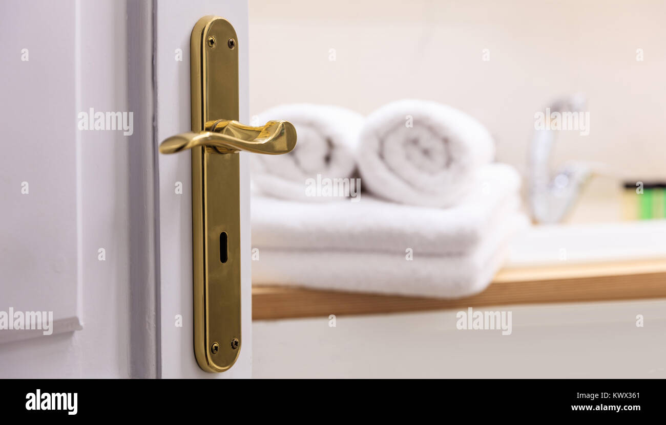 Badezimmer aus offenen Tür. Blur weißen Handtüchern gefaltet neben dem Waschbecken. Blur Hintergrund, Details der Tür. Stockfoto