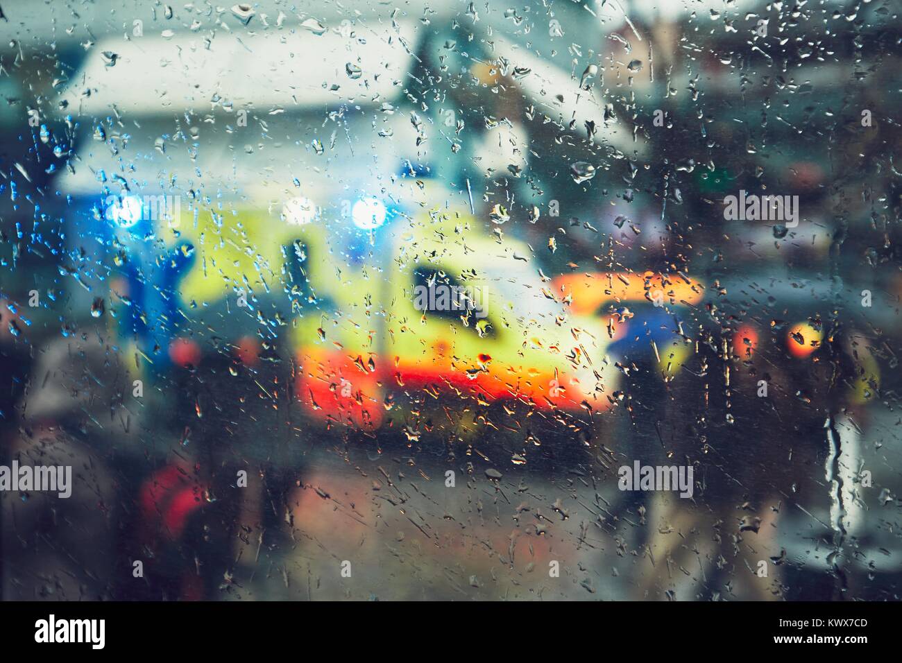 Emergency Medical Service Reaktion in der Stadt. Rettungswagen auf der Rush Street bei Regen. Blick durch ein Fenster und selektiven Fokus auf der Ra Stockfoto