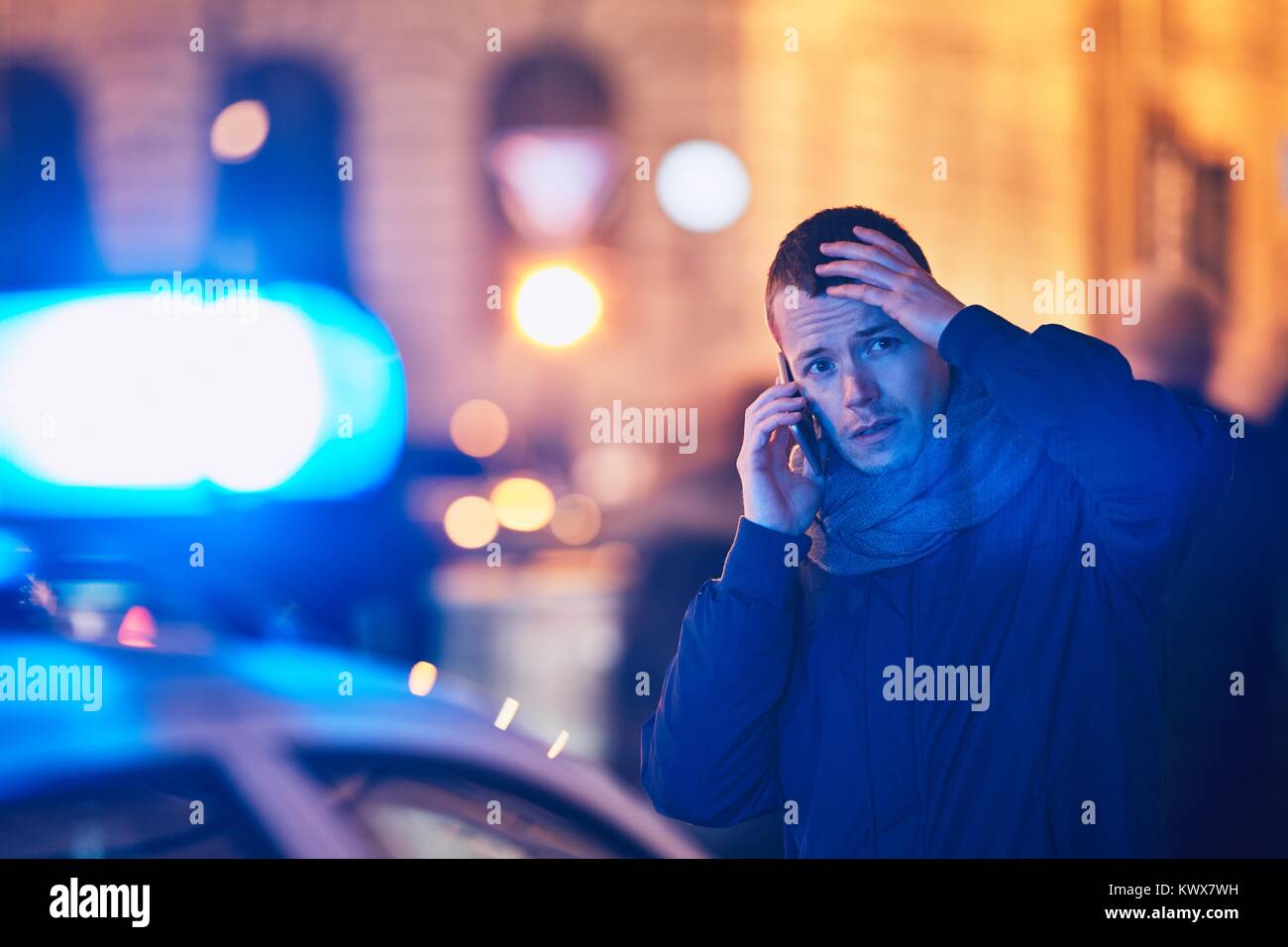 Junger Mann ruft nach einer Krisensituation auf Straße der Stadt. Themen Kriminalität, Emergency Medical Service, Angst oder helfen. Stockfoto