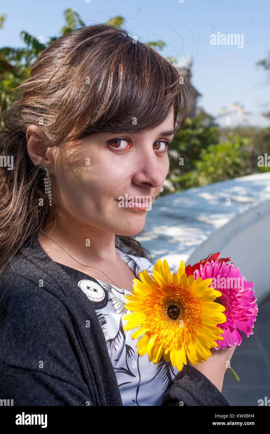 Recht attraktive Brünette mit Blumenstrauß an Kamera Bild vertikal auf der Suche Stockfoto