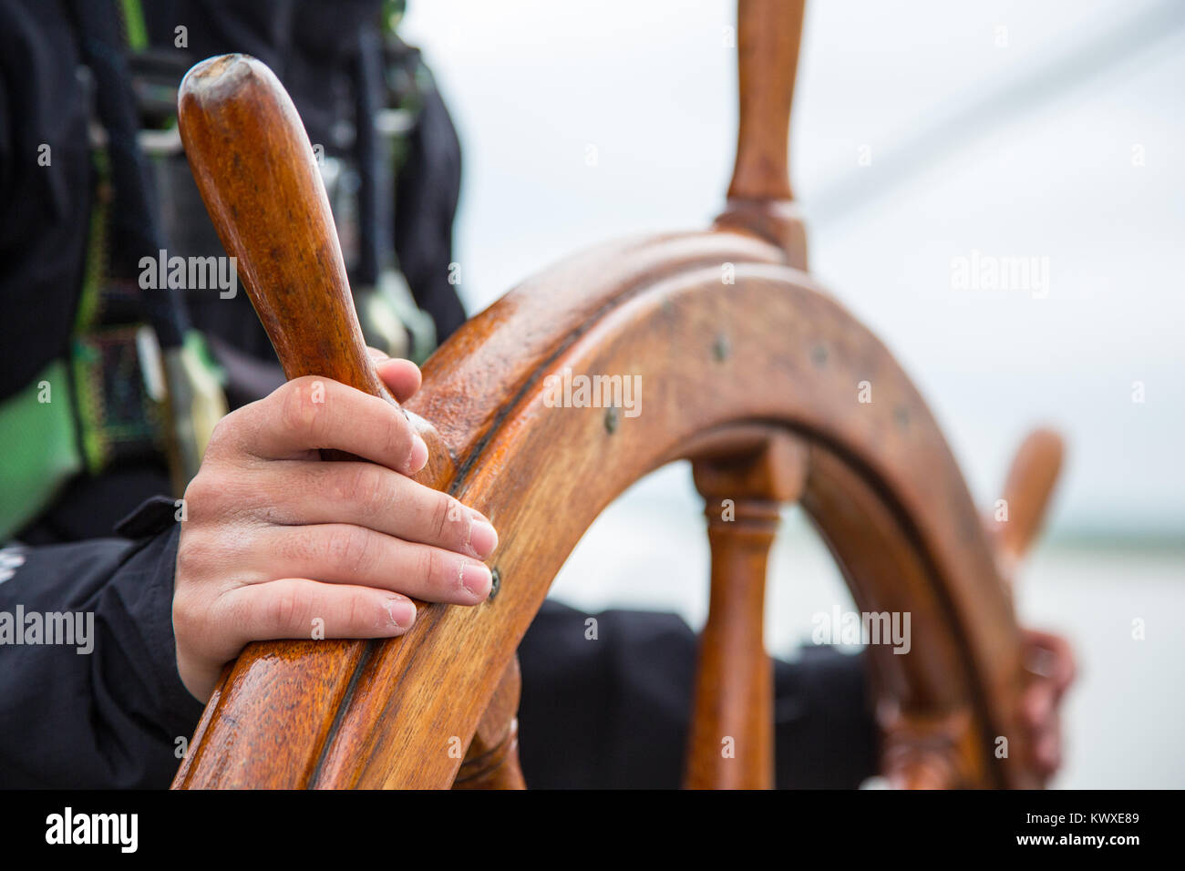 Eine junge Segler an die Spitze. Hände auf einem Segelschiffe Holz- Rad. Stockfoto