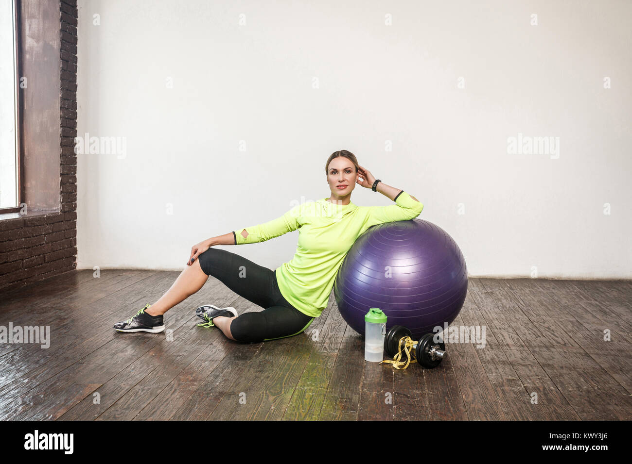 Gewichtsverlust. Viele Fitnessgeräte. Sportliche Frau Relaxin auf dem Boden. Studio shot Stockfoto
