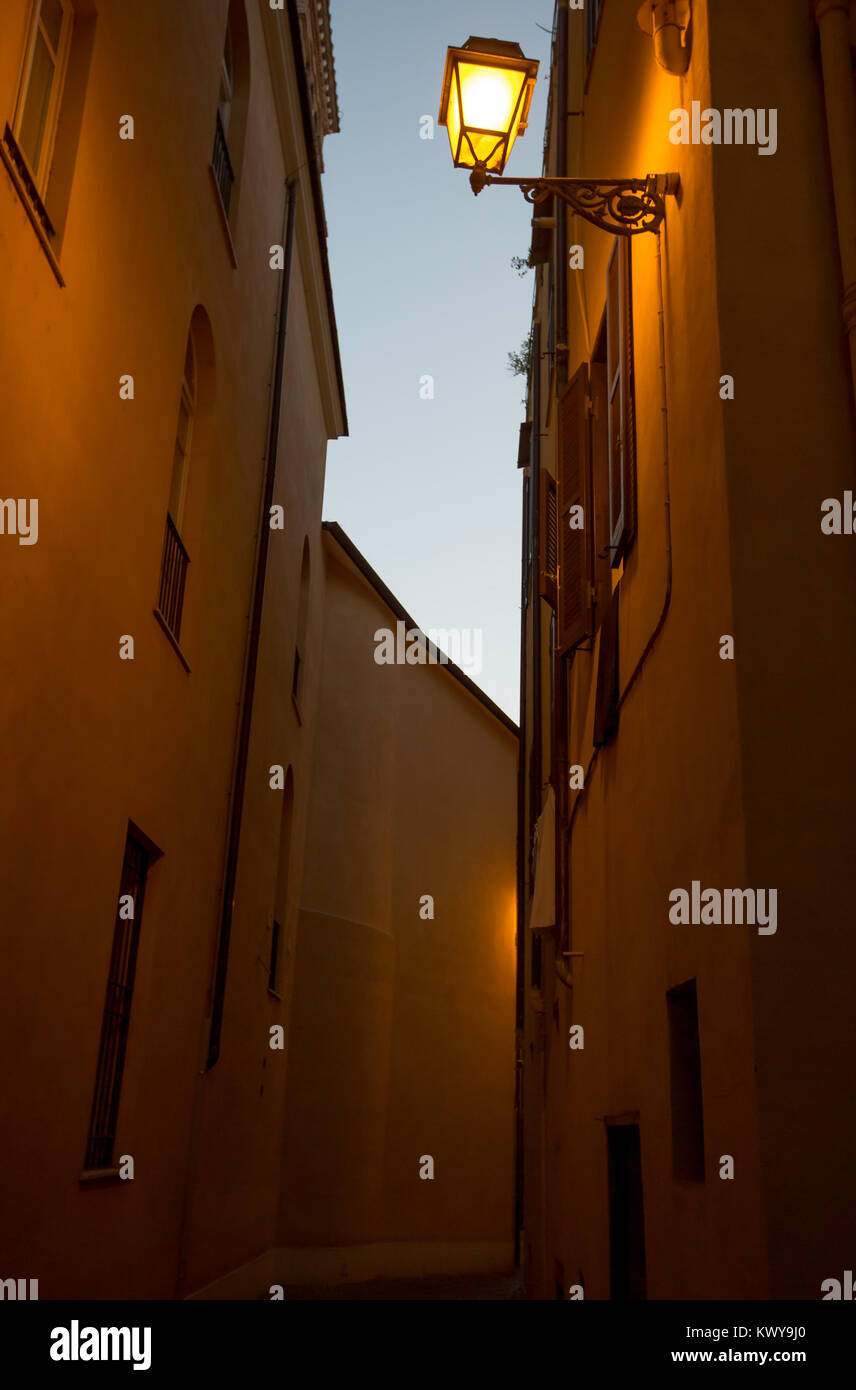 Einer warmen und ruhigen schmalen Gasse im Zentrum von Rom, mit gelbem Licht aus einem alten Licht post an der Wand. Perfekt für einen romantischen Abend laufen! Stockfoto