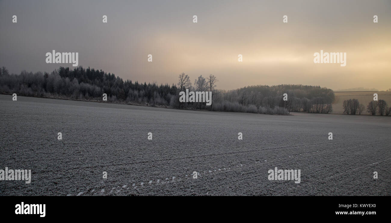 Sonnenuntergang in Wolken über Winter verschneite Landschaft Stockfoto