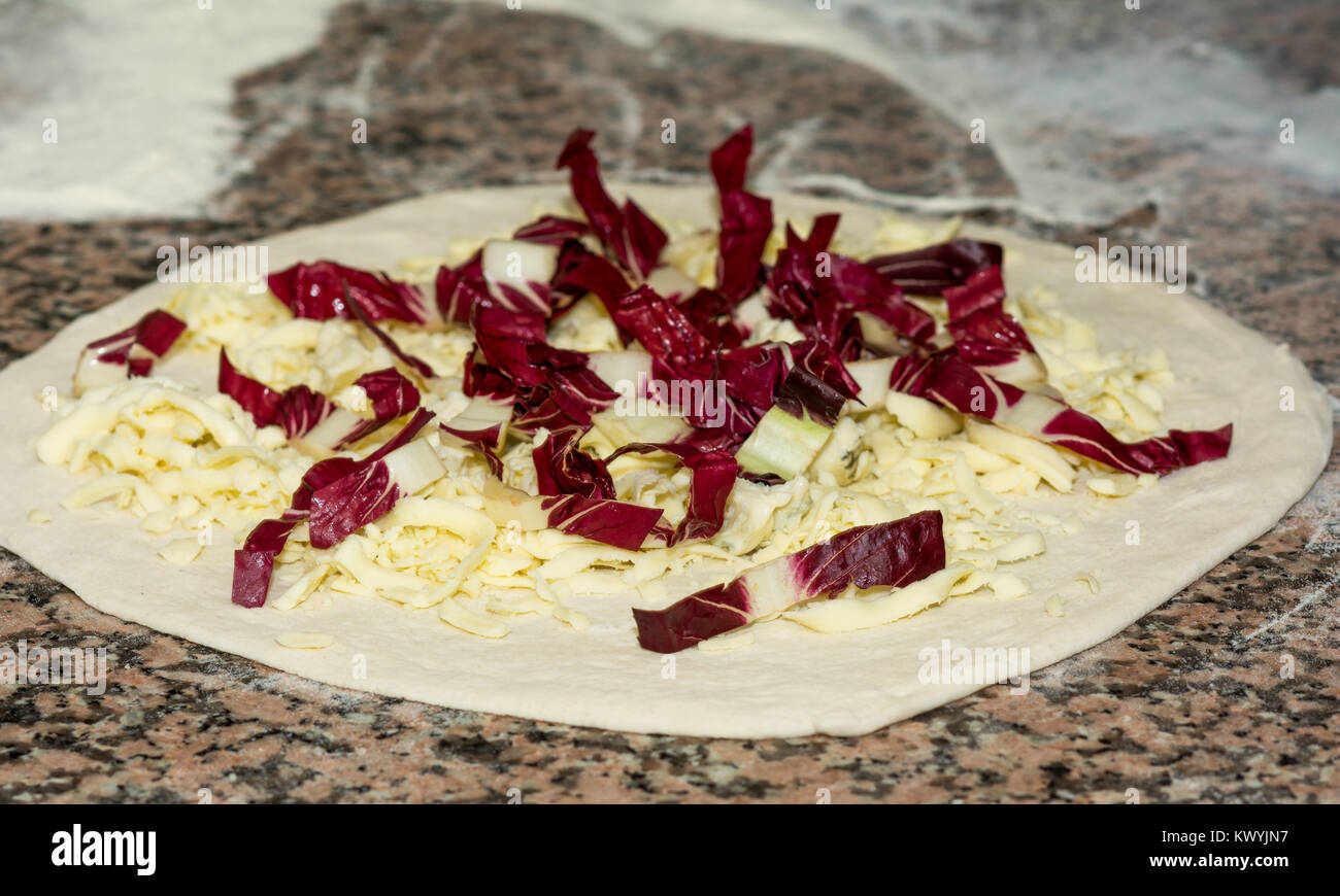 Frische rohe original italienischen Pizza, Vorbereitung des Teiges im traditionellen Stil, mit Käse und rotem Chicoree. Lebensmittel, italienische Küche und Kochen. Stockfoto