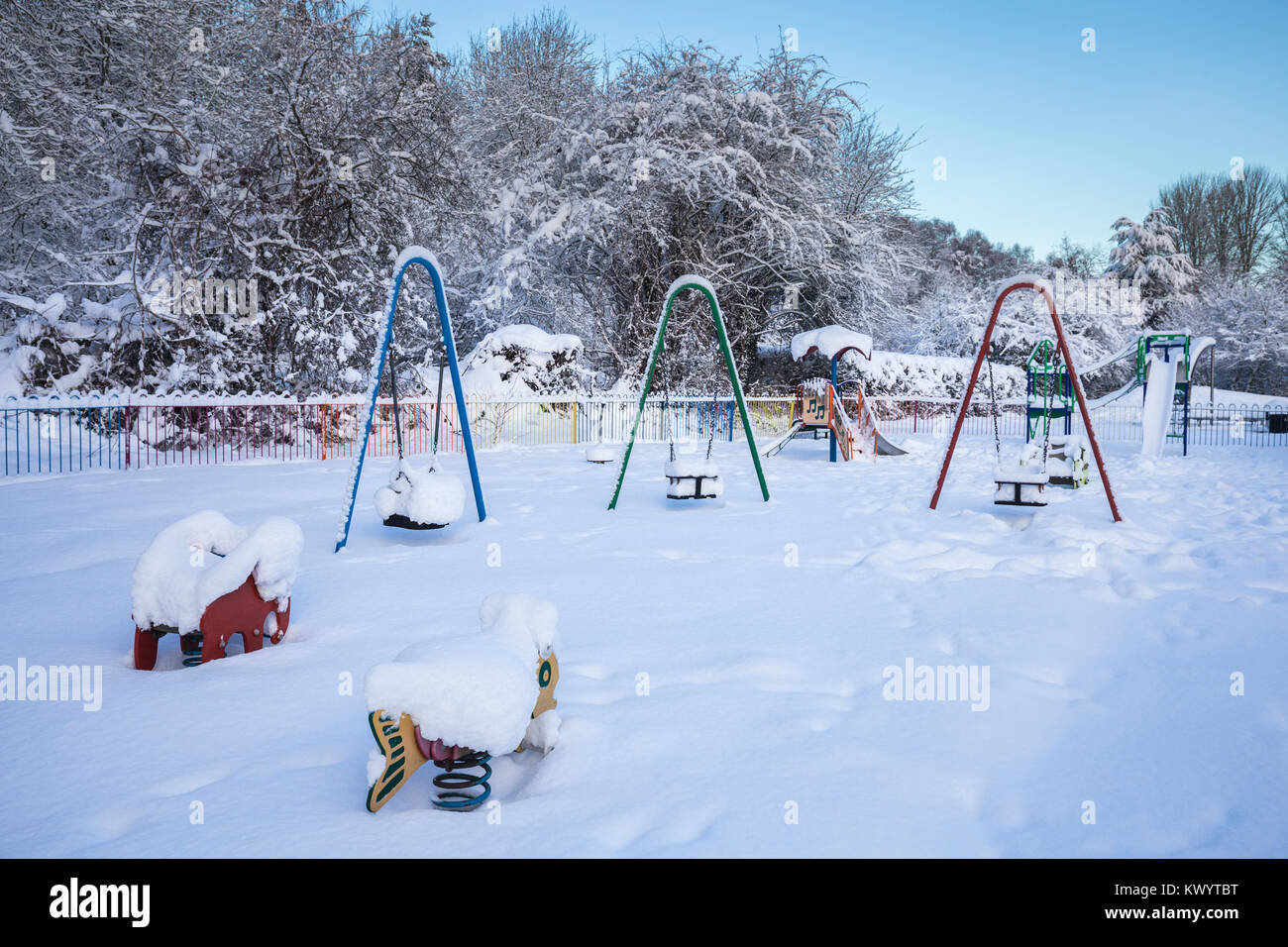 Kinder Spielplatz in tiefem Schnee im Morgenlicht abgedeckt Stockfoto