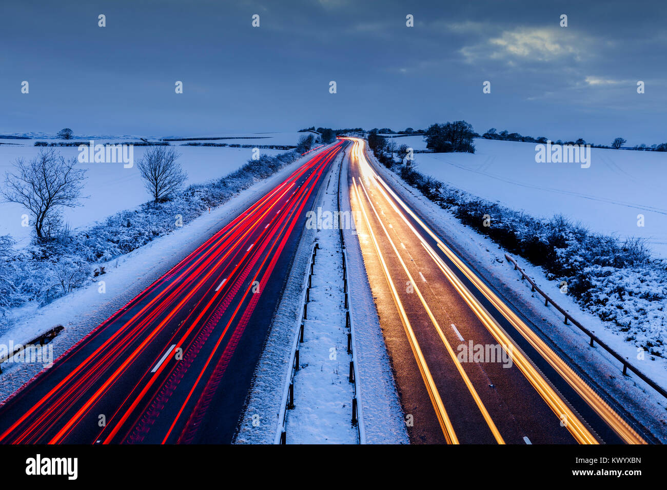 Leichte Spuren von fahrenden Autos auf den ländlichen Autobahn im Schnee im Winter. Stockfoto