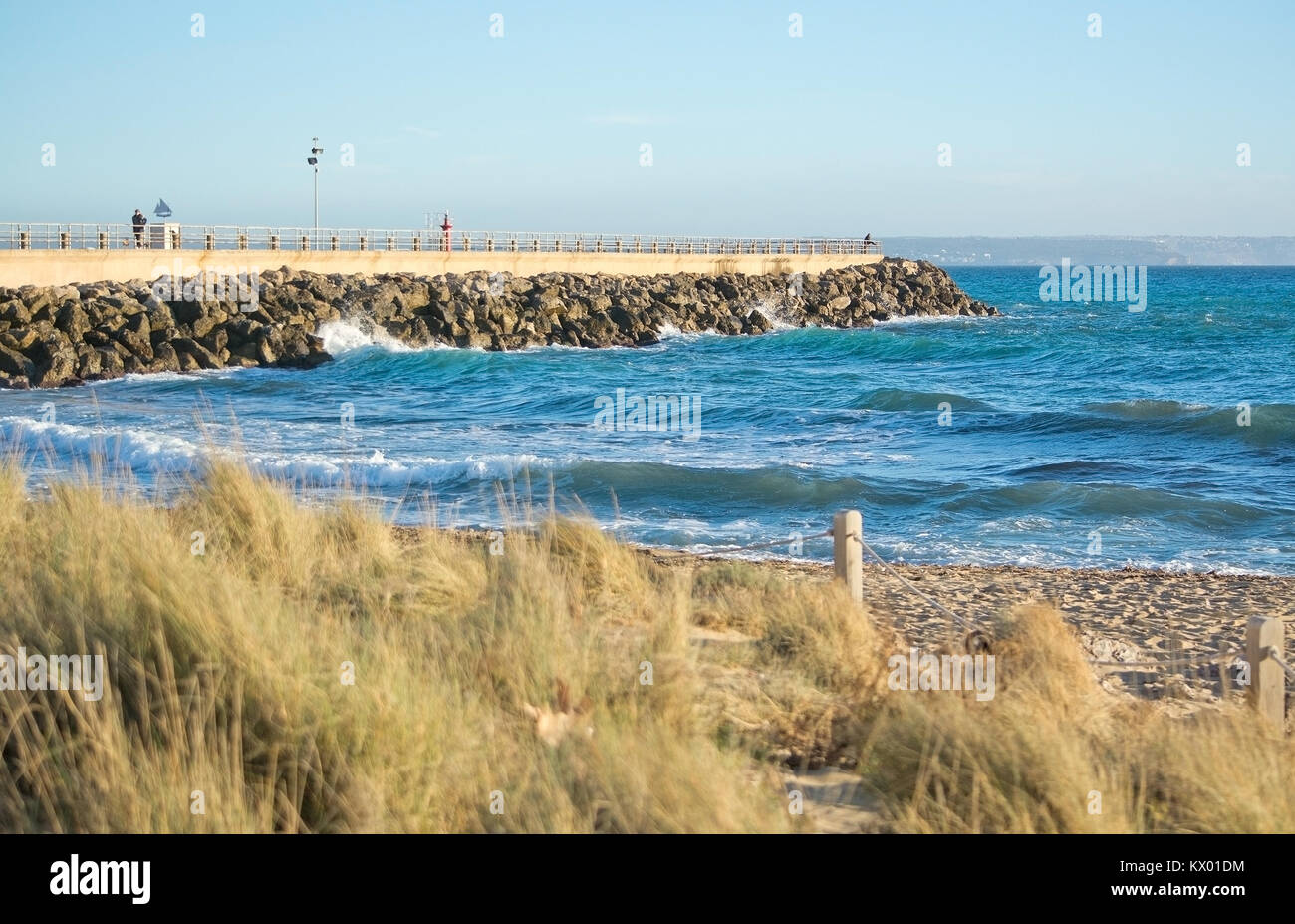 PALMA DE MALLORCA, SPANIEN - 4. JANUAR 2018: Portixol Pier Beach Gras, Sand und Wellen auf einem sonnigen Nachmittag am 4. Januar 2018 in Palma de Mallor Stockfoto