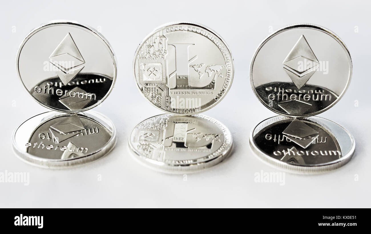 Auf einem weißen Hintergrund sind Silber Münzen eines digitalen crypto Währungen - des Astraleums und Litecoin. Zusätzlich zu den liegenden Münzen Es gibt. Stockfoto