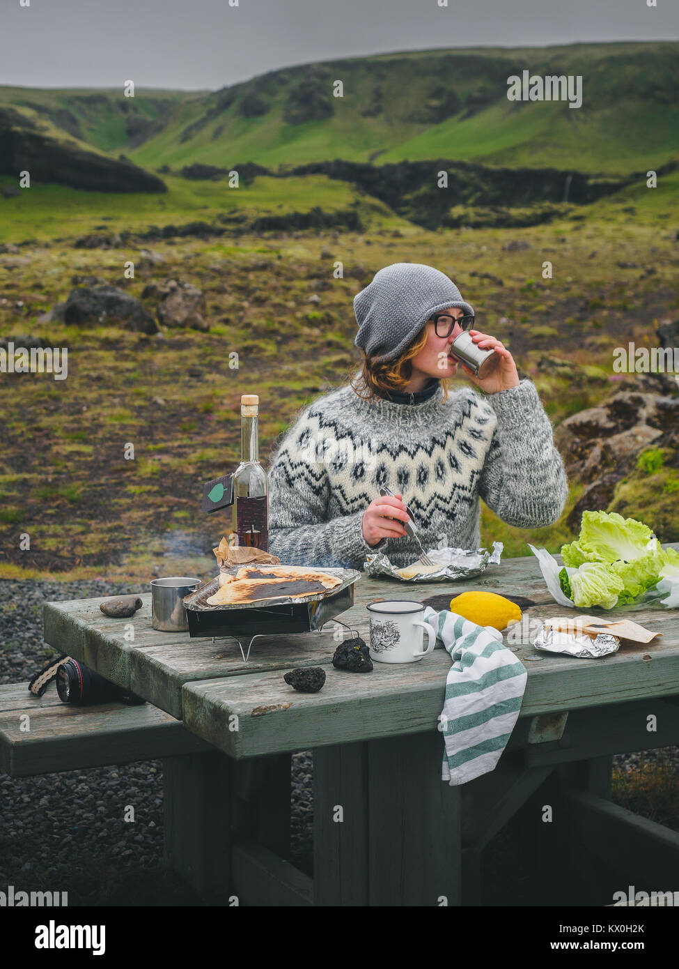 Mädchen in einem traditionellen isländischen Pullover bei einem Picknick mit einem malerischen Blick auf einem Hintergrund Stockfoto