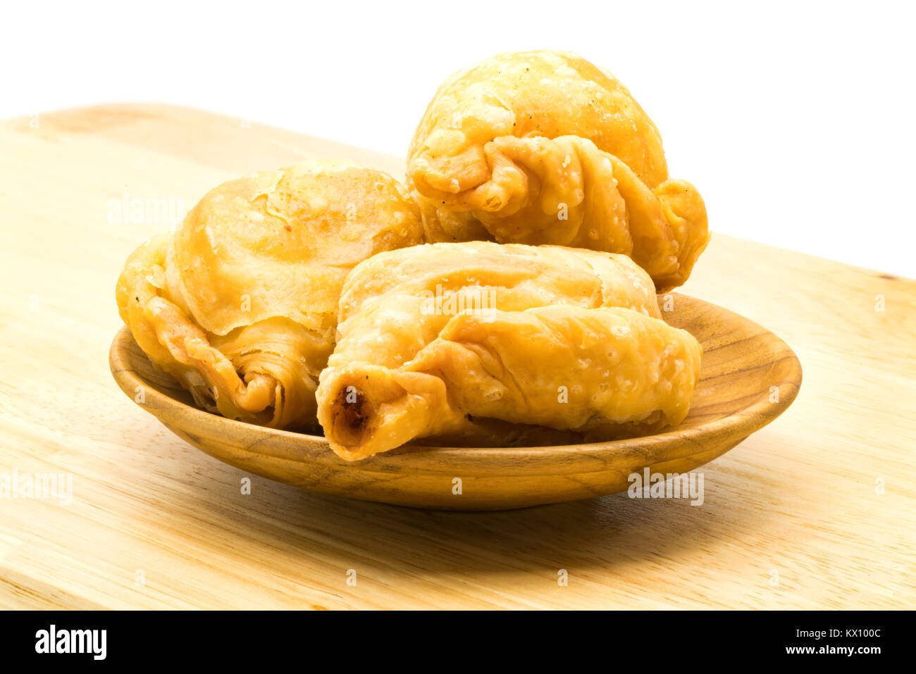 Curry Puffs in Holz- Platte auf einem Holzbrett auf weißem Hintergrund Stockfoto