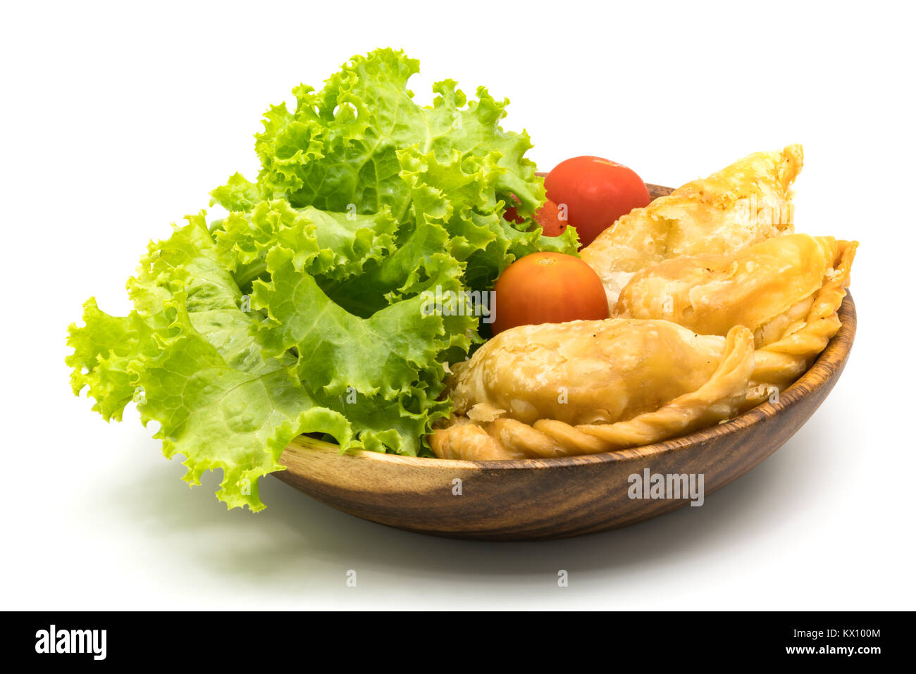 Curry Puffs, Salat und Tomaten in Houten auf weißem Hintergrund Stockfoto