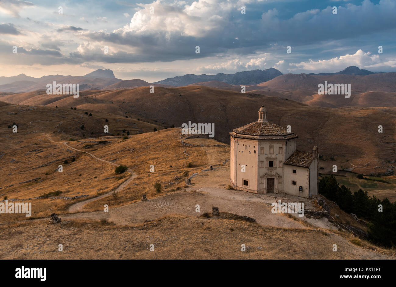 Die Kirche von Santa Maria della Pietà in der kleinen Stadt Rocca Calascio während des Sonnenuntergangs; Hauptgipfel des Gran Sasso im linken Hintergrund Stockfoto