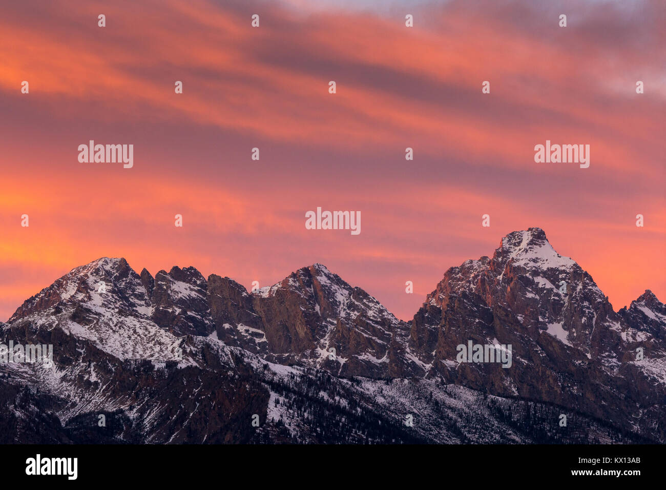 Eine glühende Sonnenuntergang beleuchtet die Gipfel der großen, mittleren und südlichen Teton. Der Grand Teton National Park, Wyoming Stockfoto