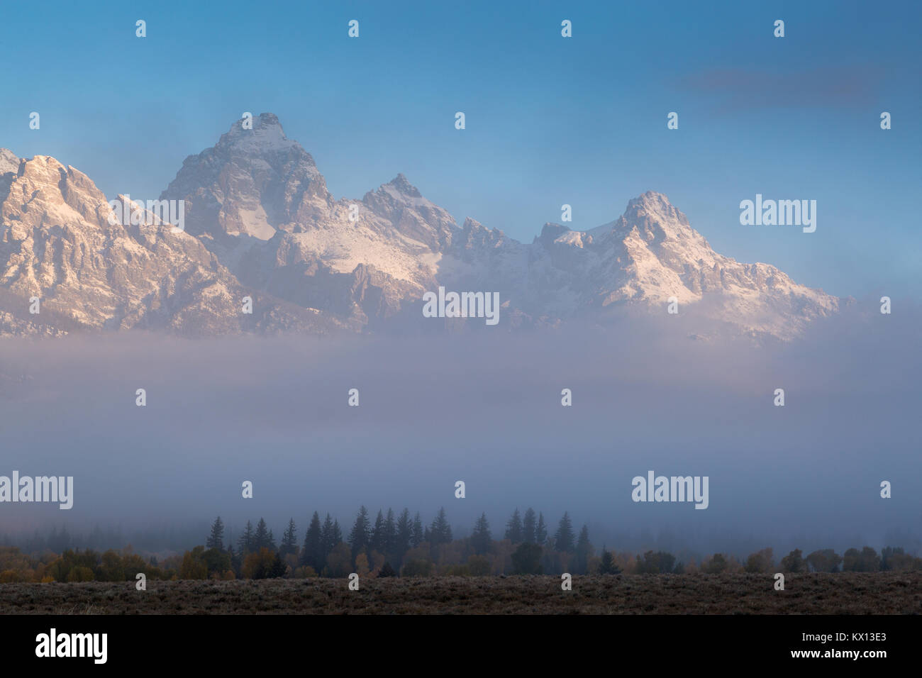 Ein dicker Nebel die den Teton Mountains bei Sonnenaufgang. Der Grand Teton National Park, Wyoming Stockfoto