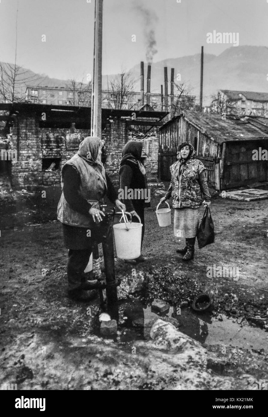 Rumänien 1994 - Frauen Sammeln von Wasser aus einem Standrohr in der Minenstadt Petrila, wo die Stadt von der lokalen Minen verschmutzt ist Stockfoto