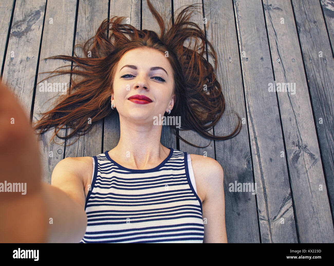 Nahaufnahme, Porträt einer jungen schönen Frau mit einem Smartphone digitale Kamera mit ihren Händen und nehmen eine selfie self portrait von sich selbst während Vernetzung. Stockfoto