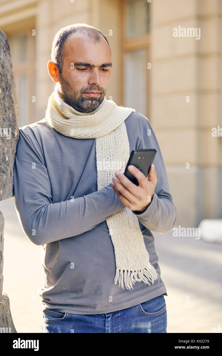 Portrait des modernen jungen Mann mit Handy auf der Straße. Stockfoto