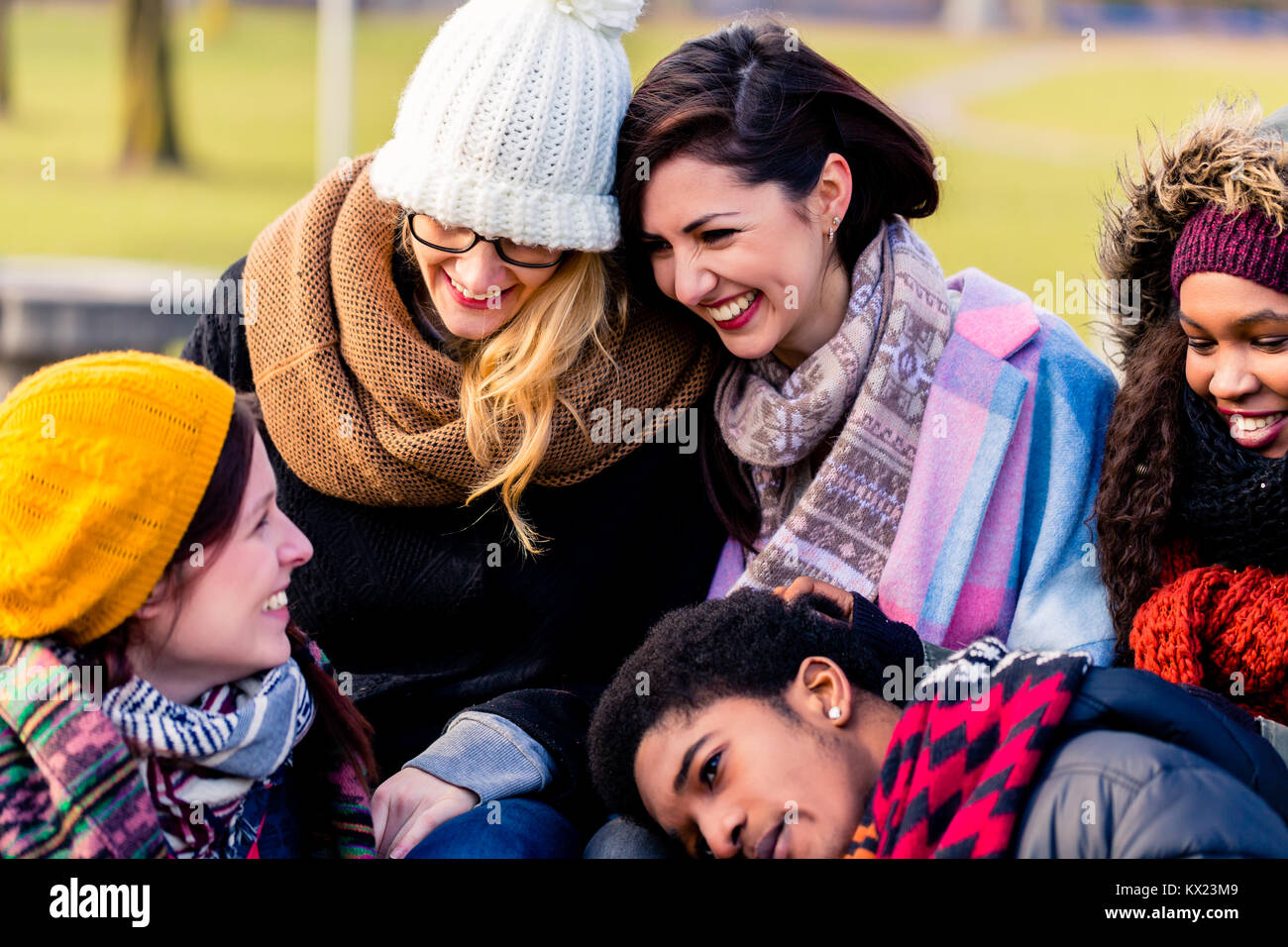 Schöne junge Menschen sitzen zusammen im Park Stockfoto