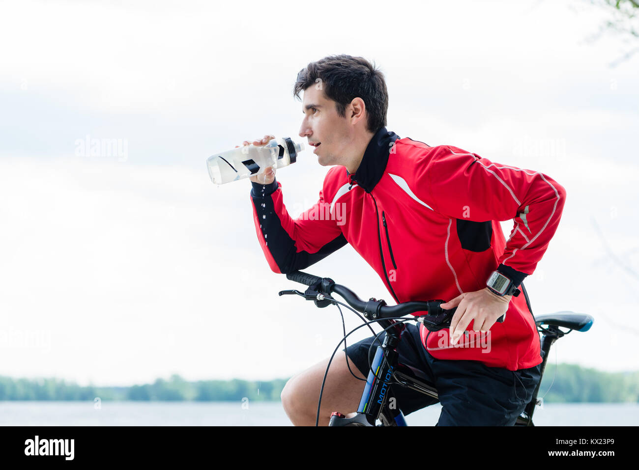 Sport Mann auf Mountainbike Trinkwasser auf Rest Stockfoto