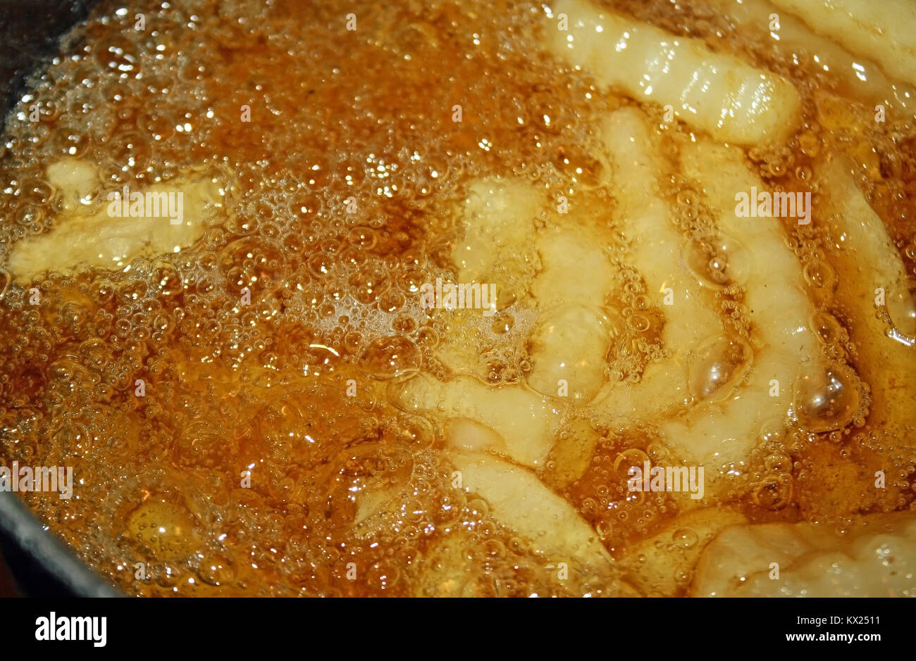 Pommes frites Kochen und Brodeln in einer Fritteuse mit Öl gefüllt Stockfoto