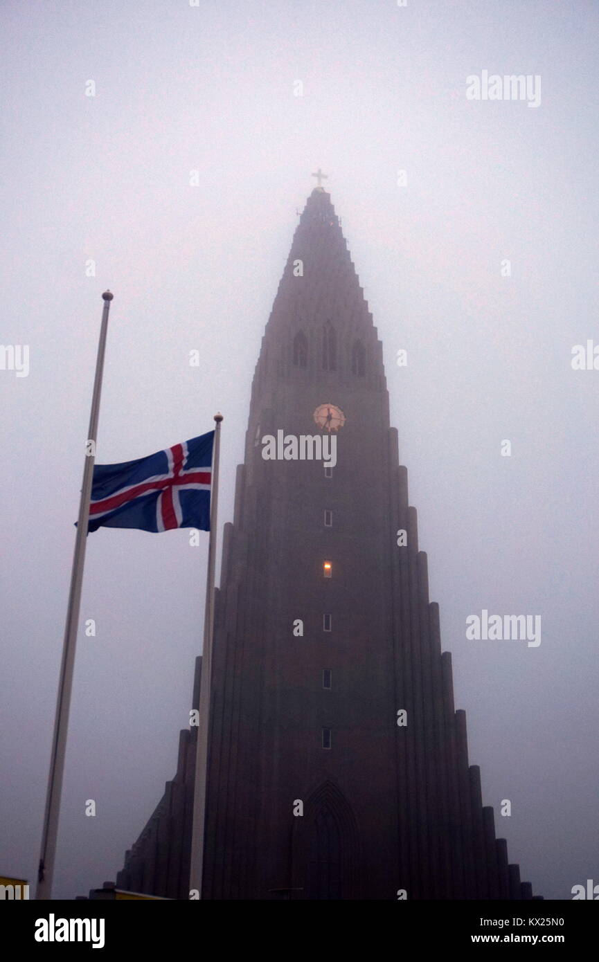 Ein isländischer Flagge außerhalb der Kirche Hallgrímskirkja im Nebel in Reykjavik, Island Stockfoto