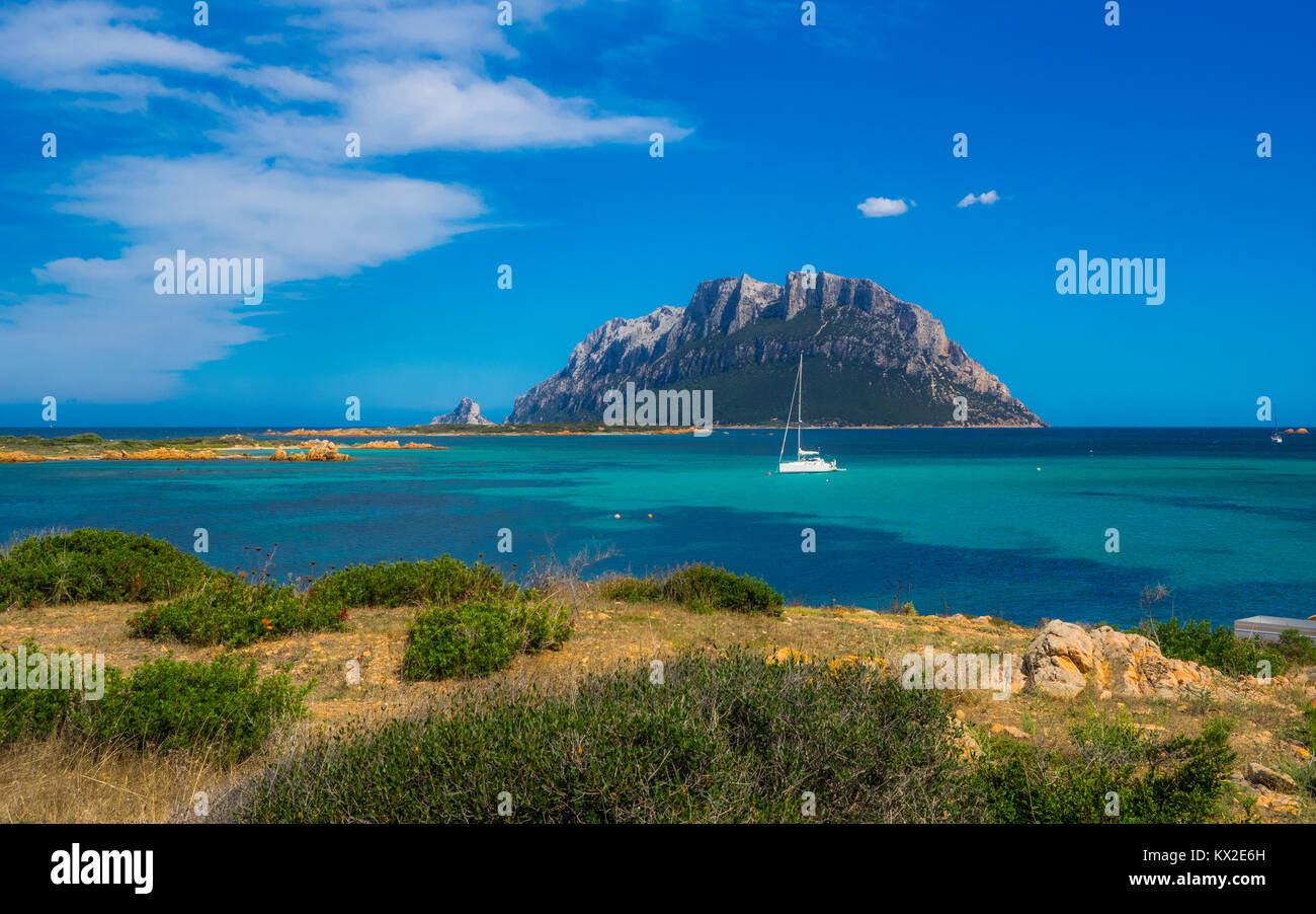 Isola Tavolara mit Segelboot an einem sonnigen Tag auf Sardinien Stockfoto