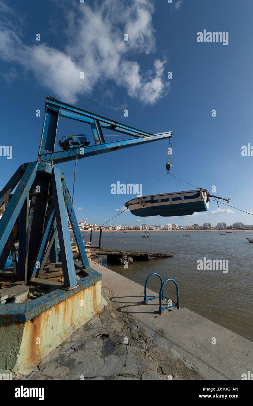 Kleines Fischerboot aus dem Hafen heraus Anheben mit dem Kran Flaschenzug wird in São Martinho do Porto, Portugal. Stockfoto