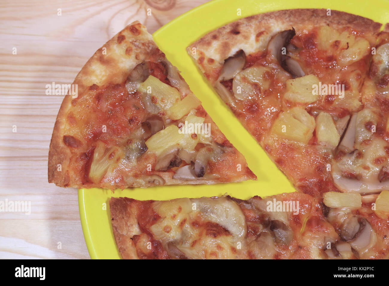 In Scheiben geschnitten Vegetarische Pizza serviert auf einem gelben Schild auf Holztisch, Ansicht von oben Stockfoto