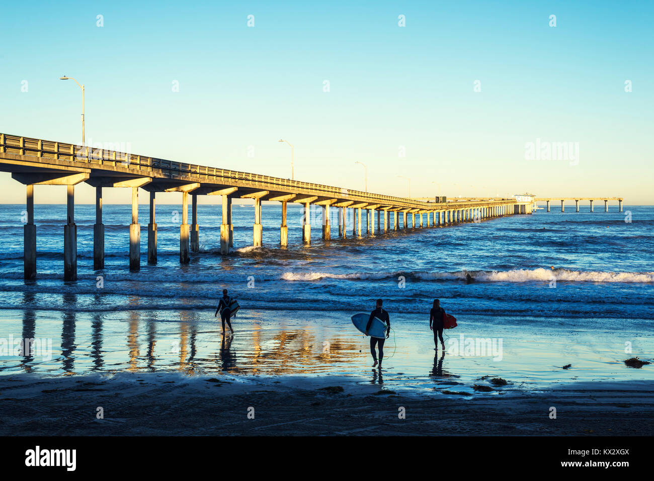 Ocean Beach Pier an einem Herbstmorgen. San Diego, Kalifornien. Drei Surfer, Surfbretter im Vordergrund. Stockfoto
