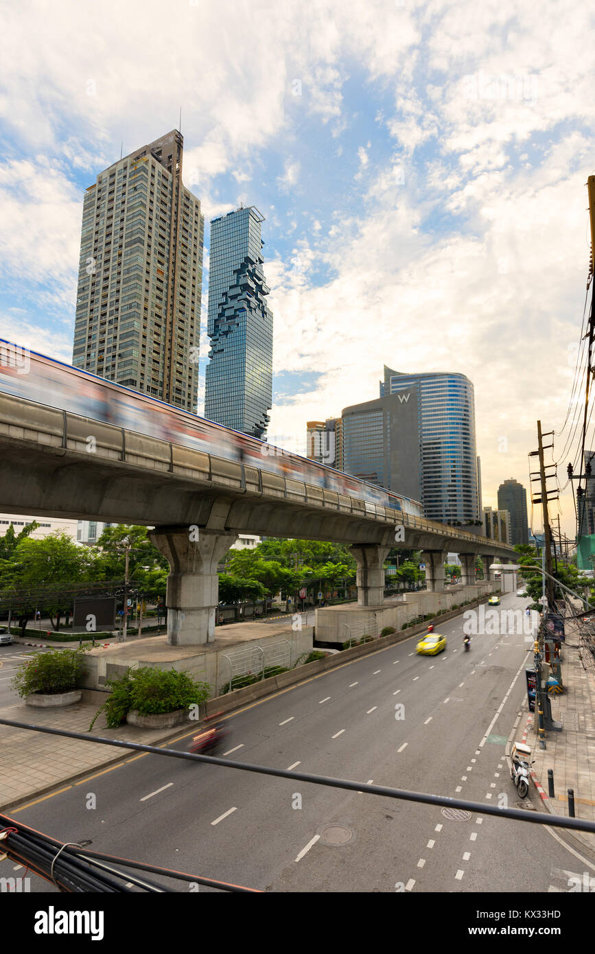 Ein Mono Rail Sky Train von Bangkok verwischt Vergangenheit auf dem Weg zum MahaNakhon Hochhaus Gebäude in der Silom/Sathon central business district in Bangkok, Stockfoto