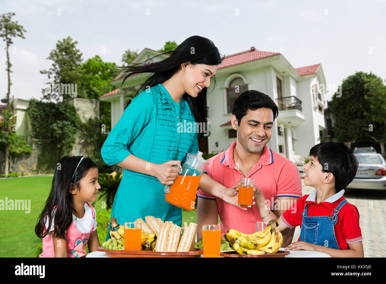 Glückliche Familie, Mutter, Saft, der Sohn Morgen Frühstück im Innenhof Stockfoto