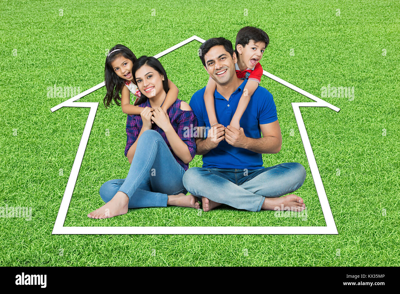 Glückliche Familie sitzen Gras Traumhaus in Park Immobilien- Konzept Stockfoto