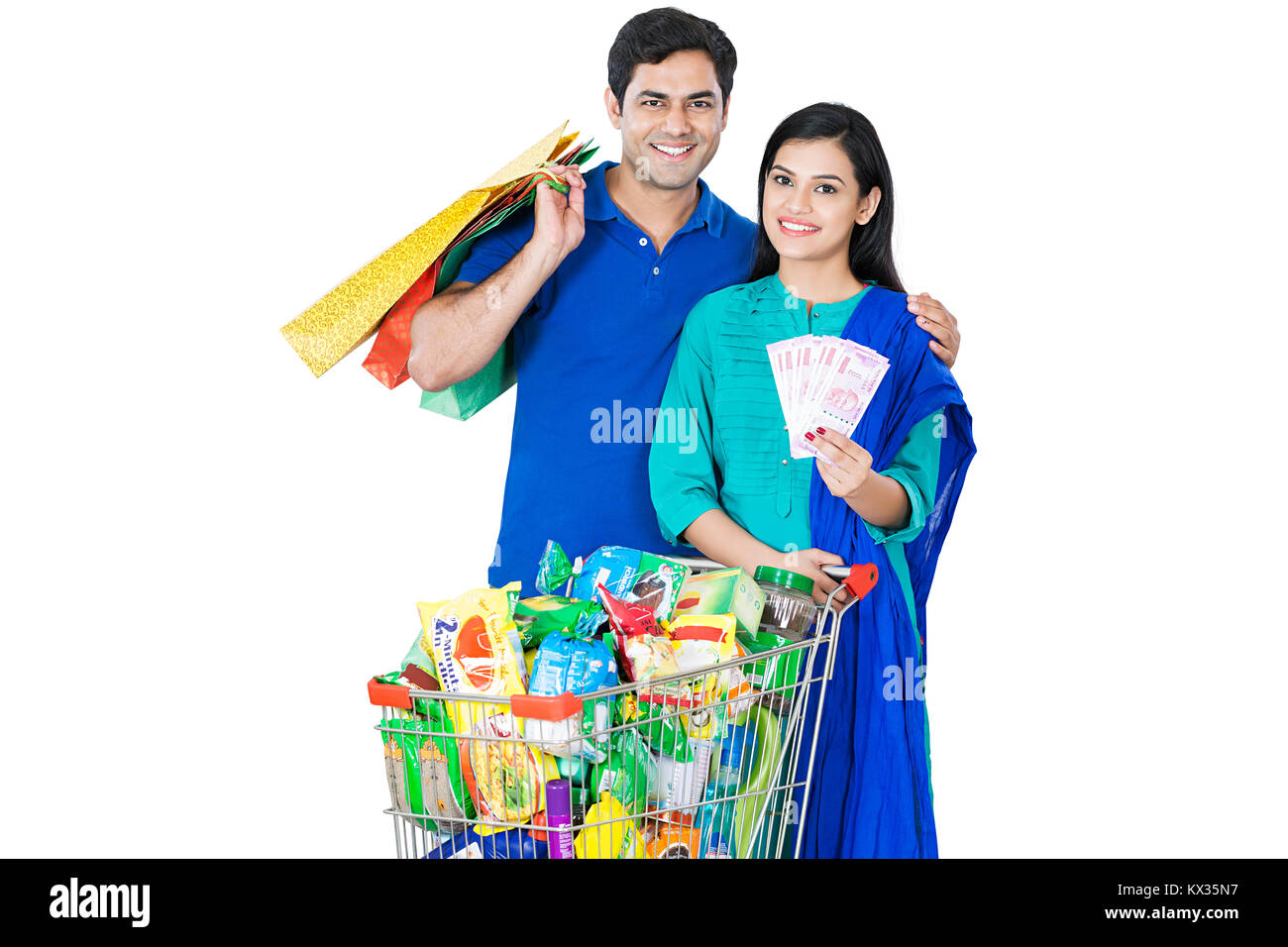 Paar mit Geld und Shopping-Bag mit Warenkorb voller Lebensmittel Stockfoto
